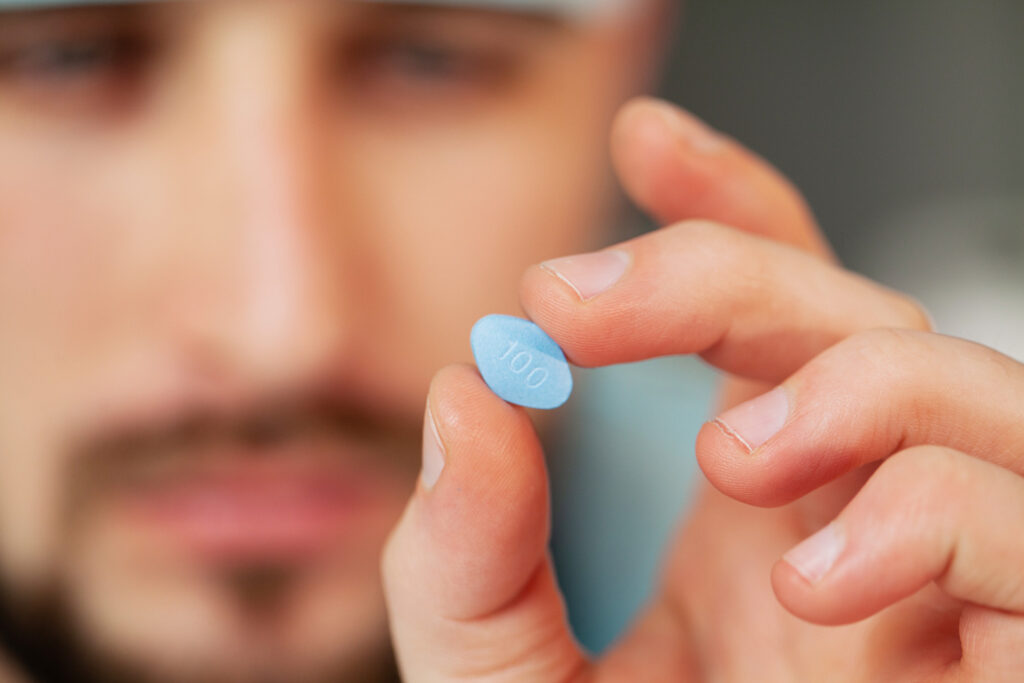 Viagra webshop sildenafil tartalmú kék tabletta közelről férfi kézben
